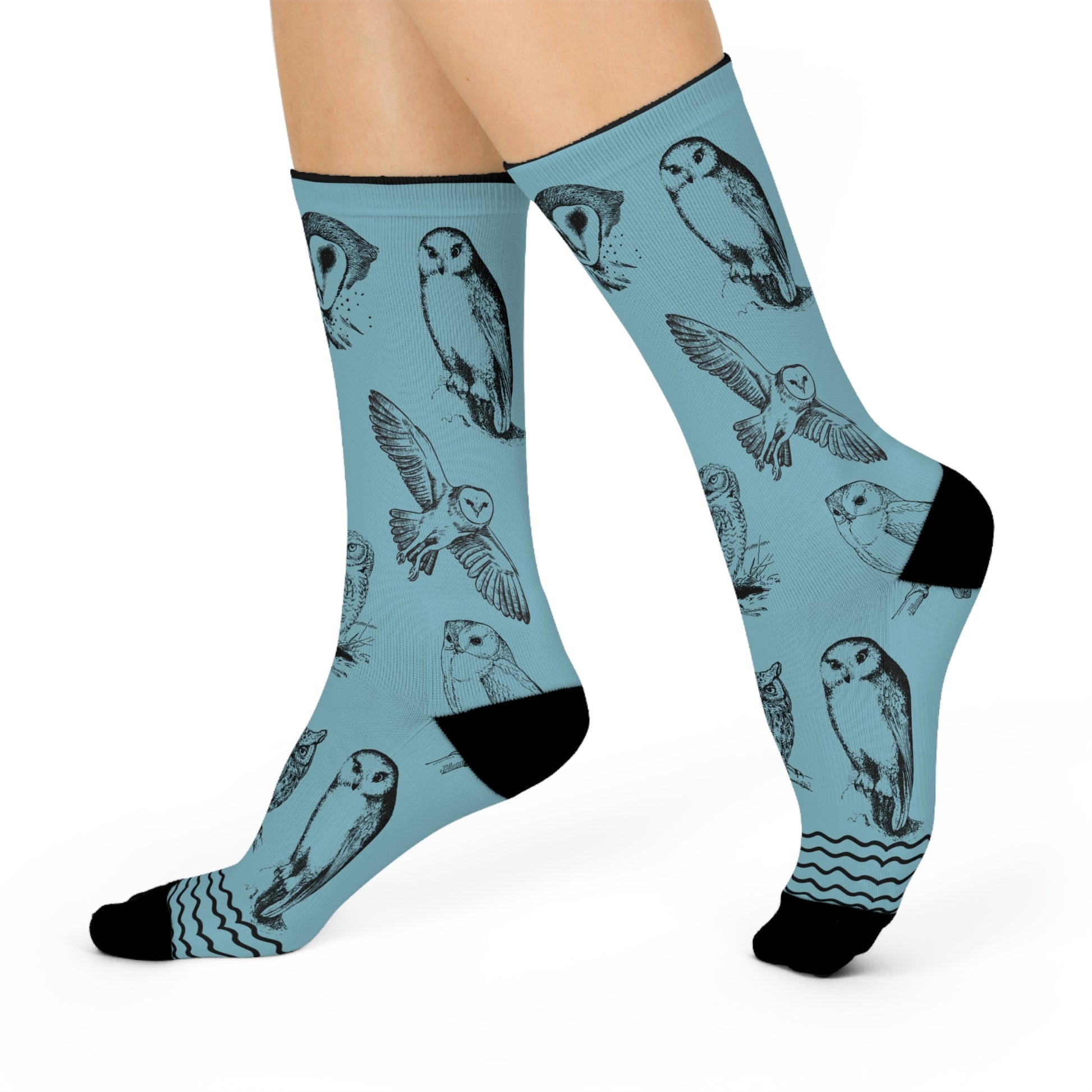 A pair of blue socks with owl patterns, designed for mid-calf coverage.