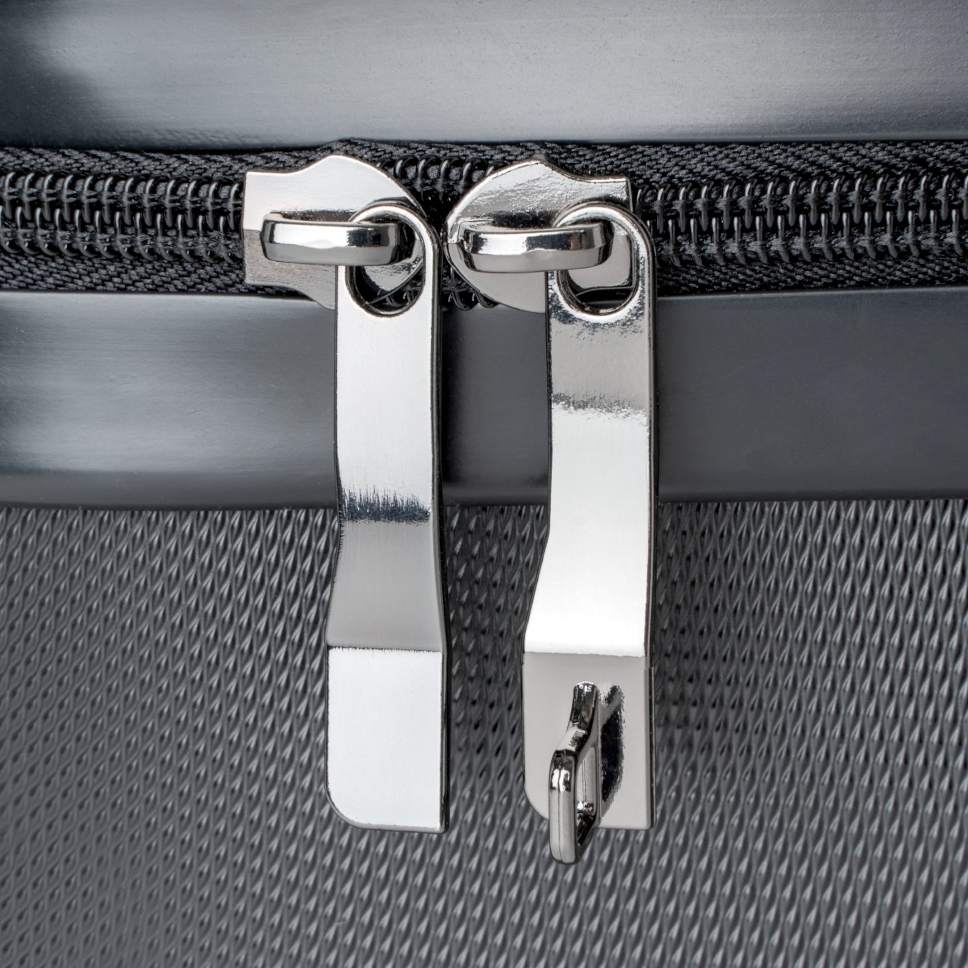 detailed view of stainless steel zipper tabs on suitcase