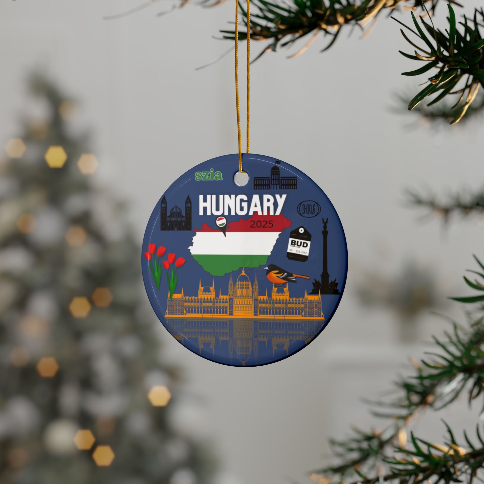 Round ornament with Hungarian design hanging on a tree branch.