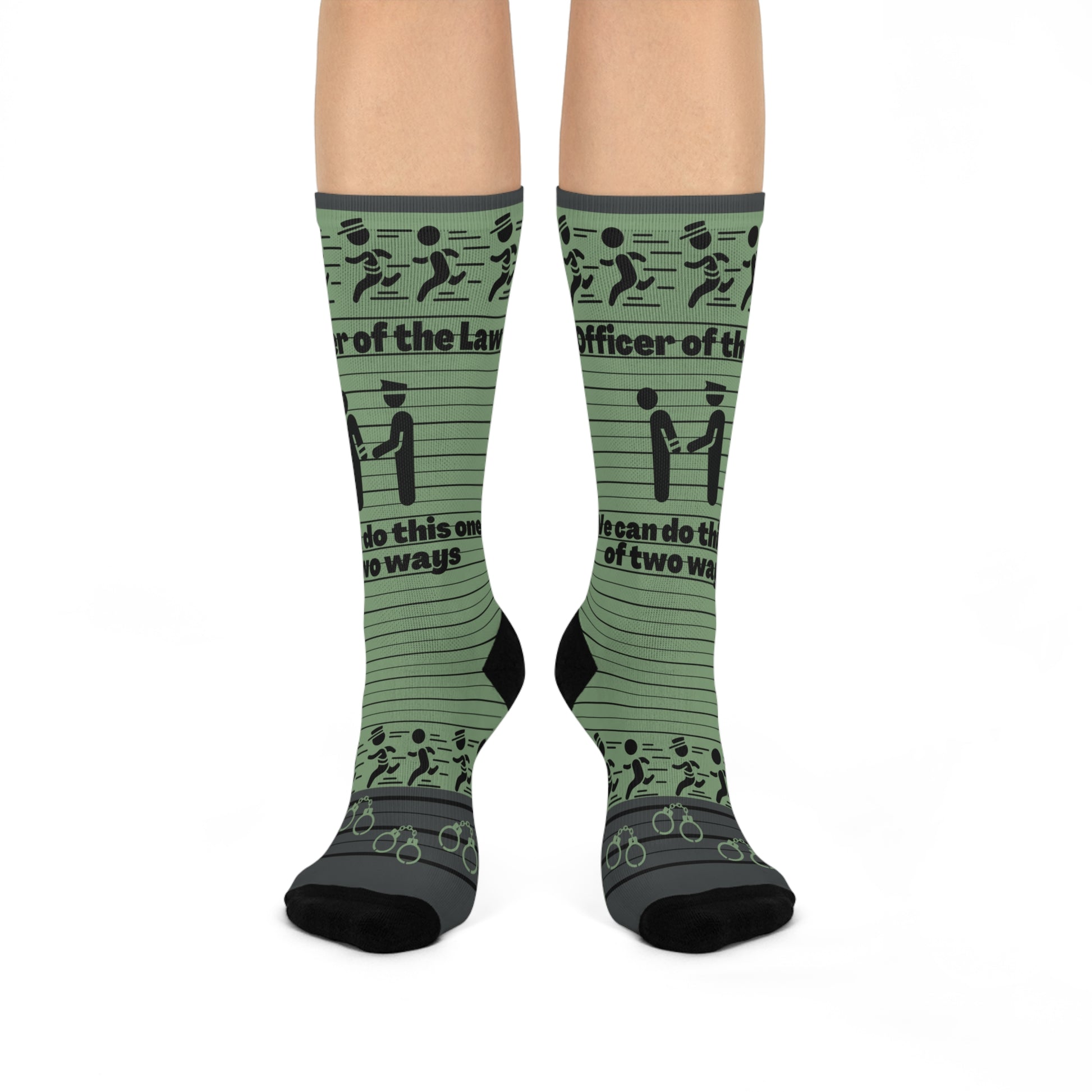 A pair of green crew socks with text and graphic patterns related to law enforcement, including phrases such as 'Law and Order' and 'Officer of the People'.