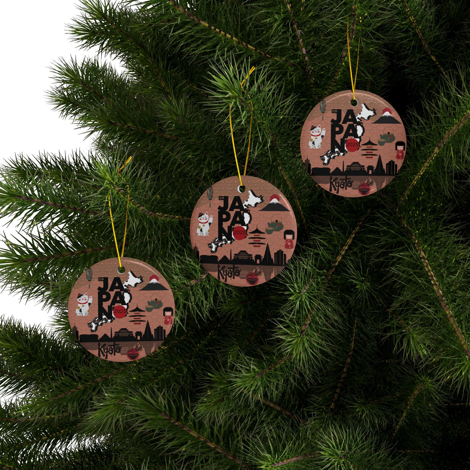 Three wooden ornaments with Japanese-themed designs hanging on a Christmas tree.
